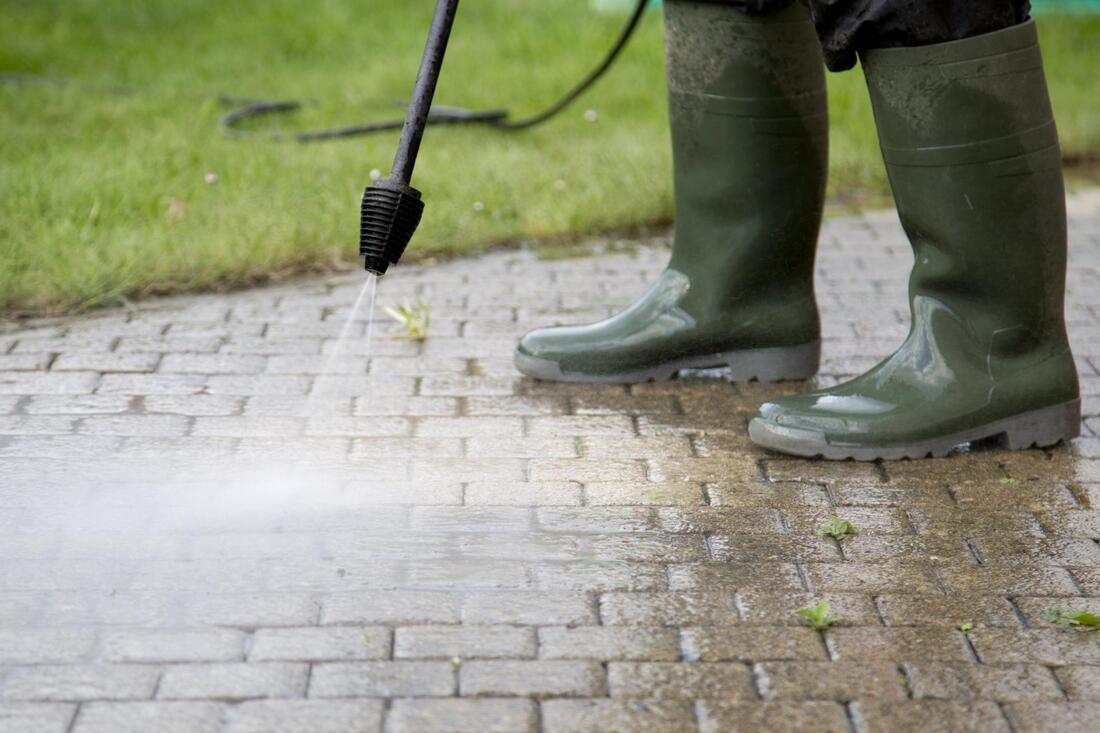 a man cleaning the driveway